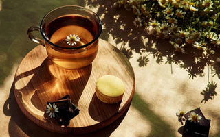 Cup of calming herbal tea with tulsi, brahmi, and spearmint surrounded by fresh herbs